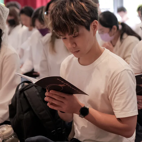 與會者手持法本恭誦